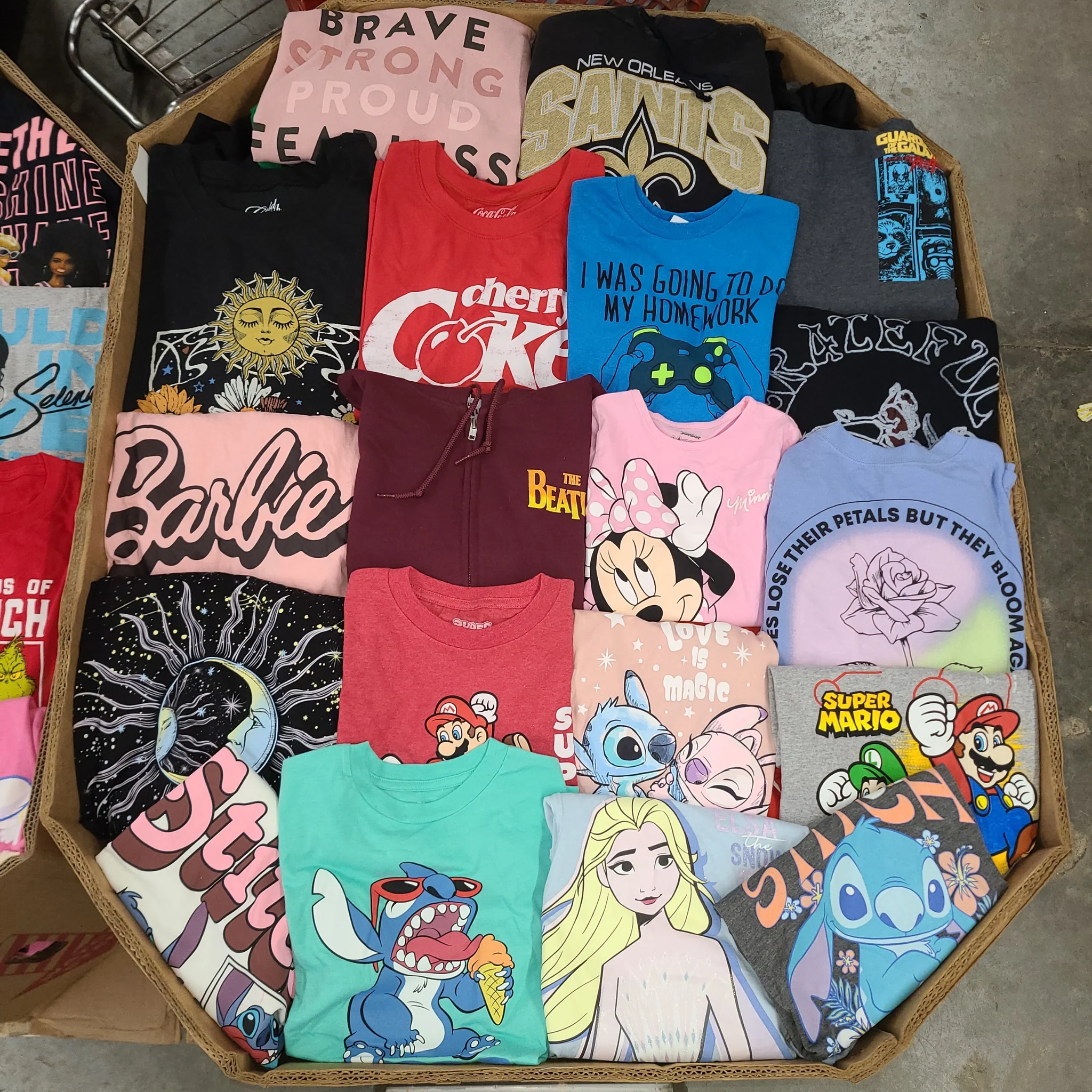 Licensed Graphic Tees Wholesale Lot with 700 brand-new licensed graphic T-shirts and sweatshirts in mixed kids' and adult sizes.