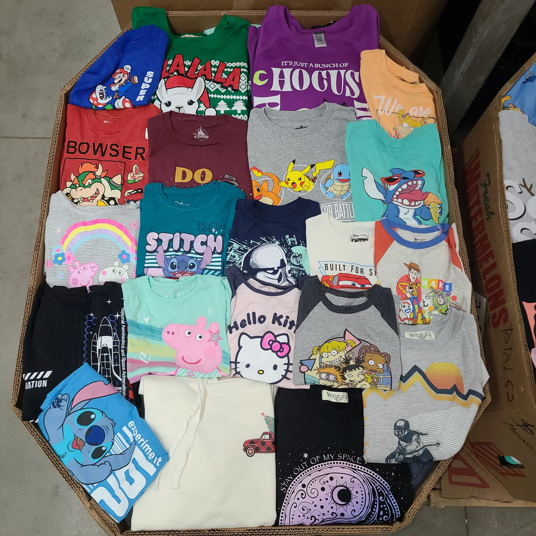 Licensed Graphic Tees Wholesale Lot with 700 brand-new licensed graphic T-shirts and sweatshirts in mixed kids' and adult sizes.