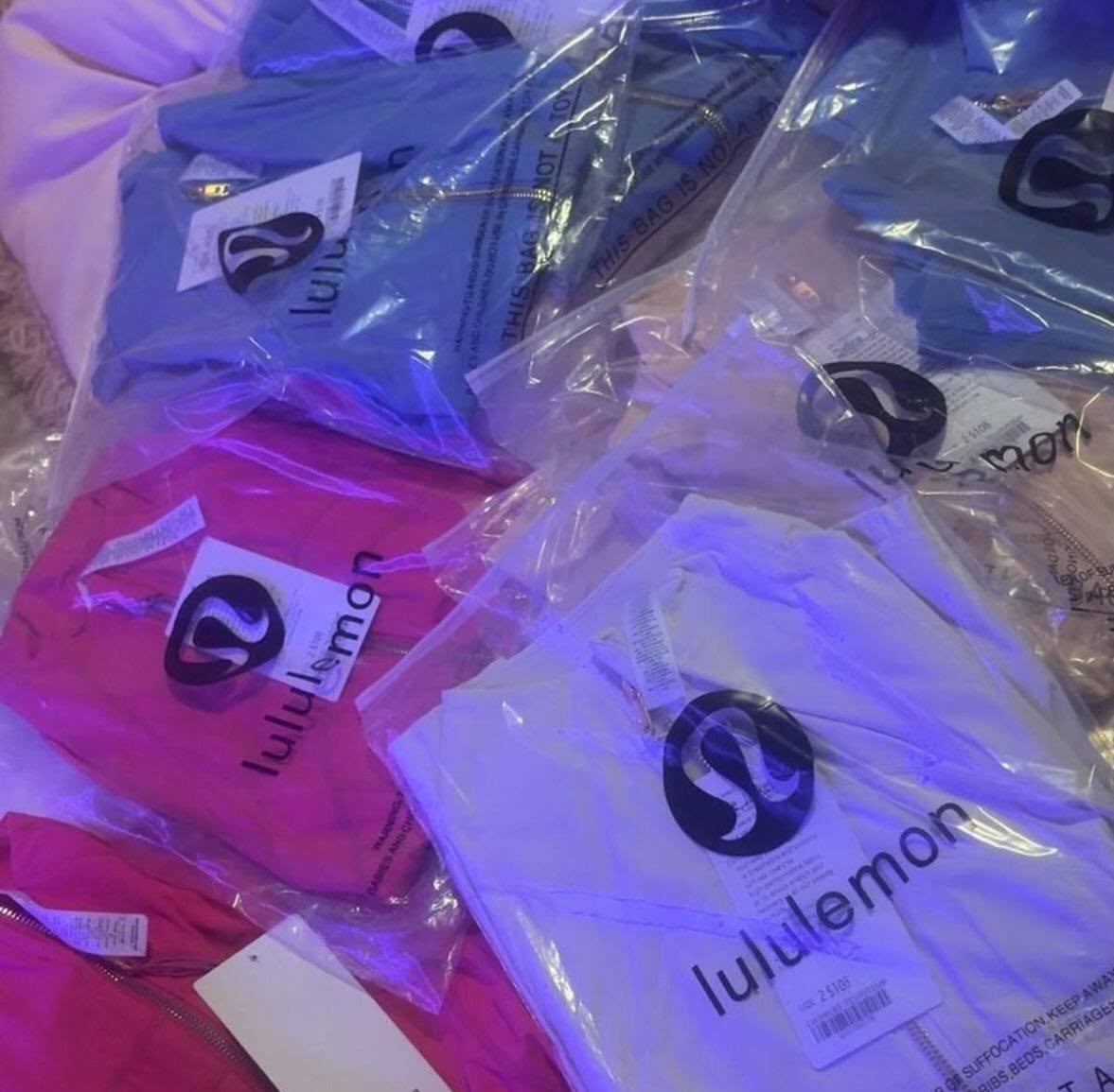 Lululemon Liquidation Pallets stacked with wholesale activewear including leggings, sports bras, hoodies, jackets, and premium athletic clothing for resale.