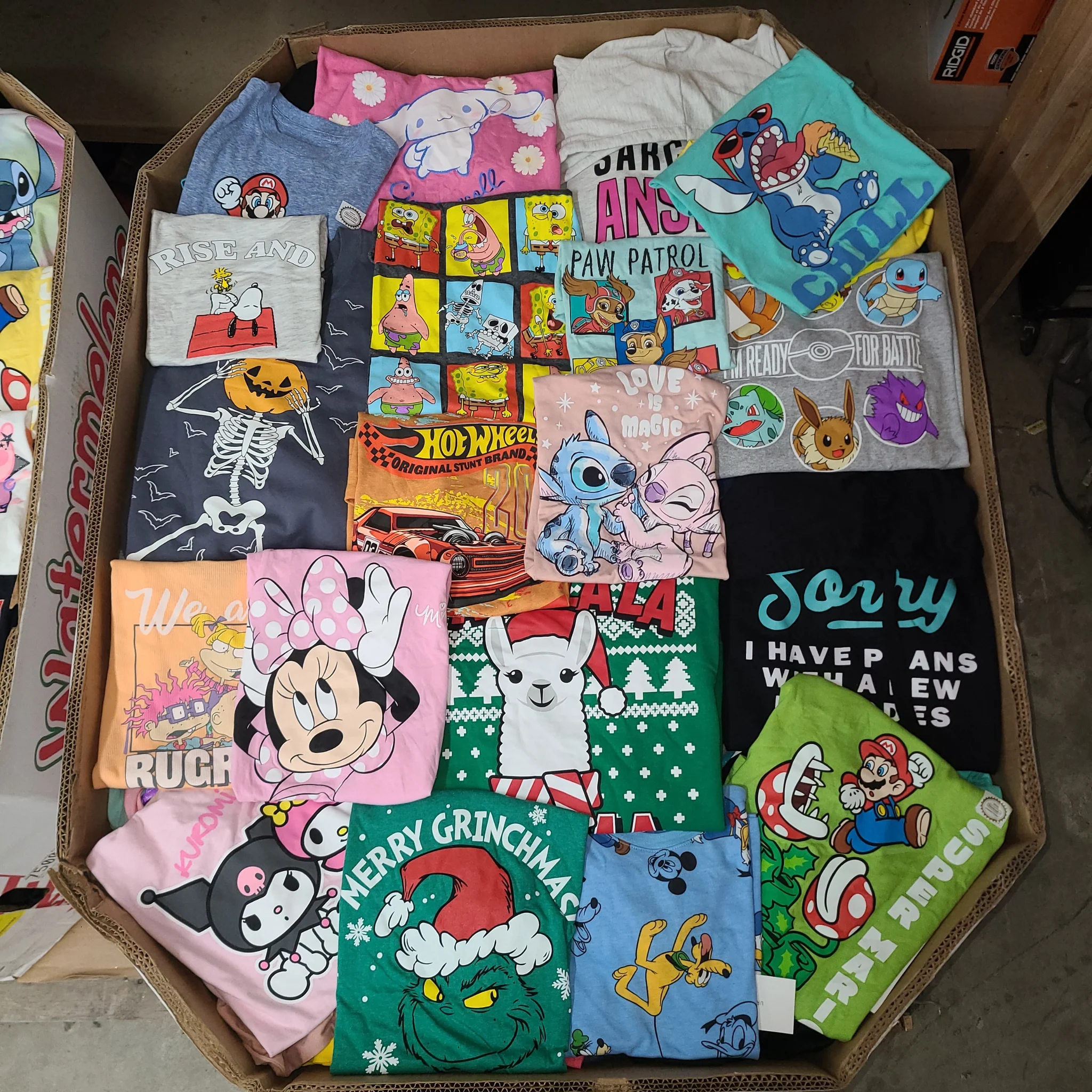 Licensed Graphic Tees Wholesale Lot with 700 brand-new licensed graphic T-shirts and sweatshirts in mixed kids' and adult sizes.